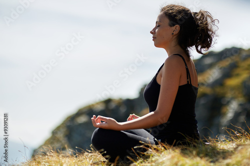 Woman practicing yoga on mountain