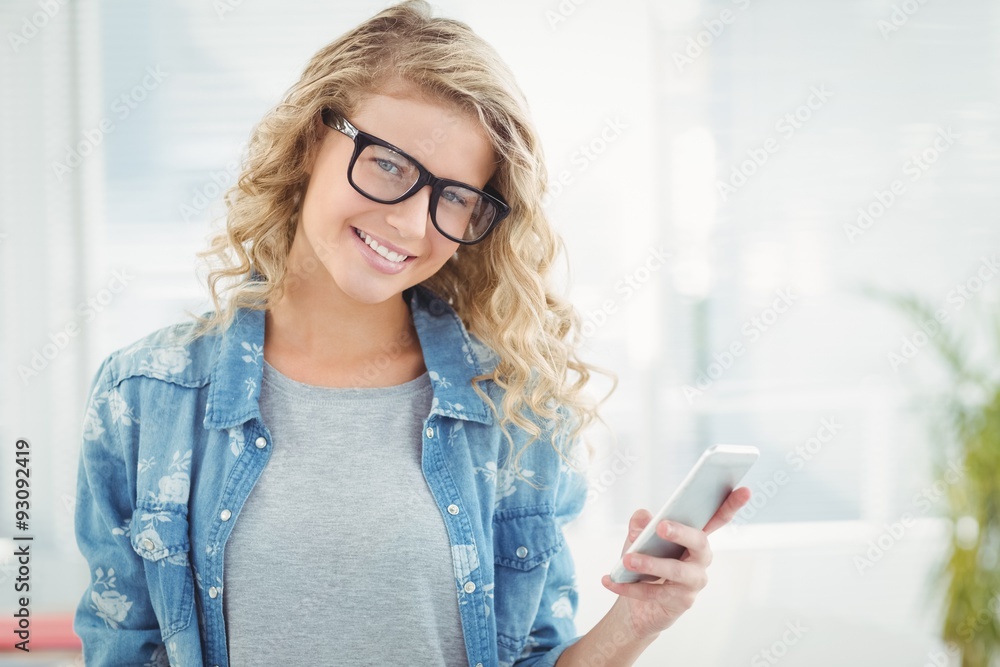 Portrait of smiling woman holding a smartphone