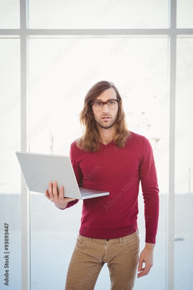 Portrait of creative businessman holding laptop Portrait of creative businessman holding laptop