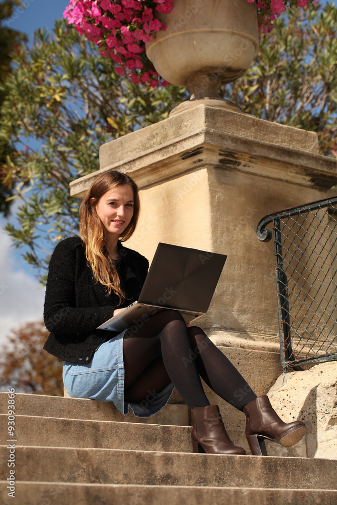 Femme en jupe et bas assise avec un ordinateur portable Stock Photo | Adobe  Stock