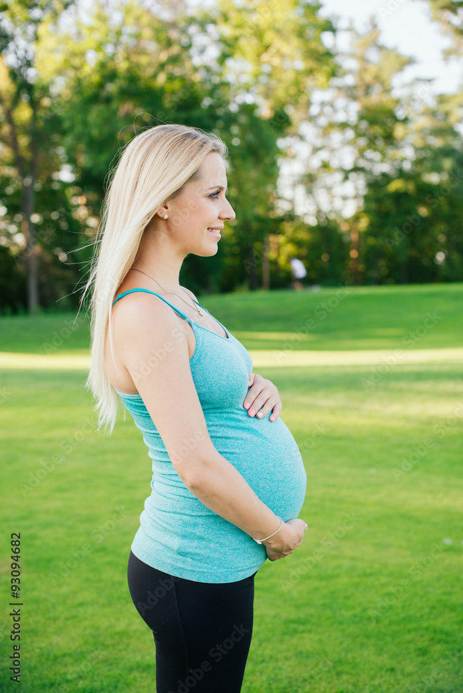 Profile view of pregnant women in sport costume in park Profile view of pregnant women in sport costume in park