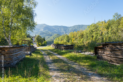 The Ennstal Alps in Upper Austria. The national park Limestone Alps known as Hintergebirge. Stacked wood along a gravel road. Timber economy is a major economic factor in Austria