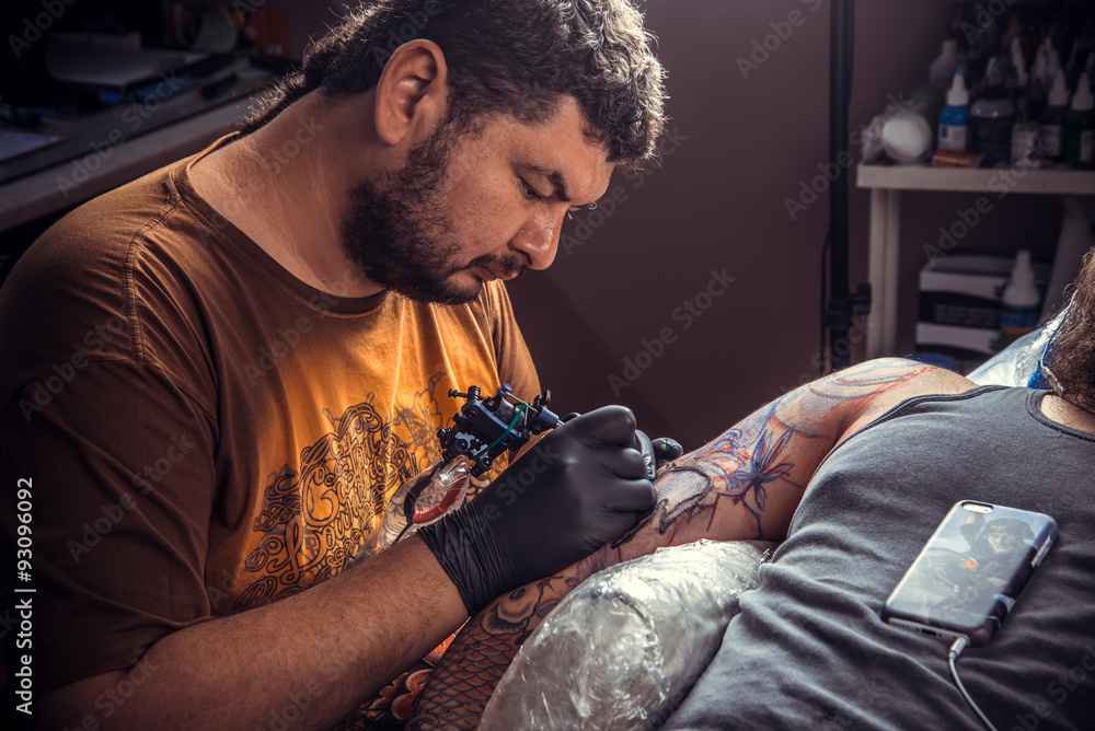 Professional tattoo artist makes tattoo in tattoo studio