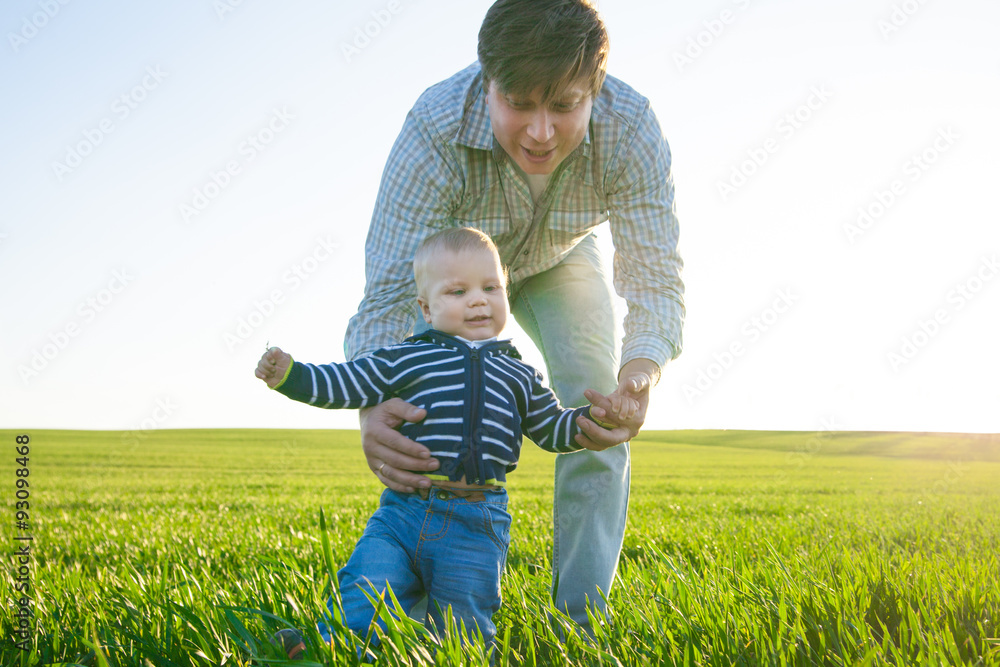 Young father and his son having fun, playing on green field Young father and his son having fun, playing on green field