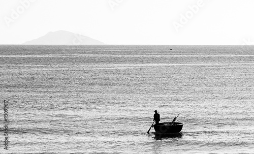 Fisherman in round boat on the sea in black and white vintage style
