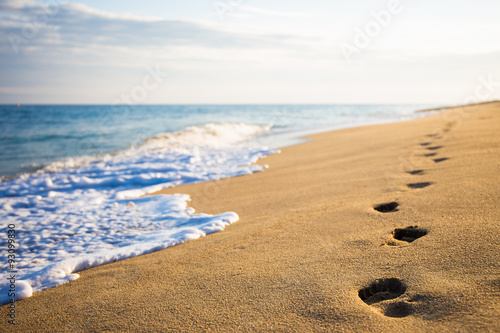 close up of footprints on sandy beach