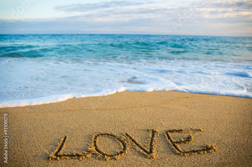 travel concept - word love written in sand on the beach