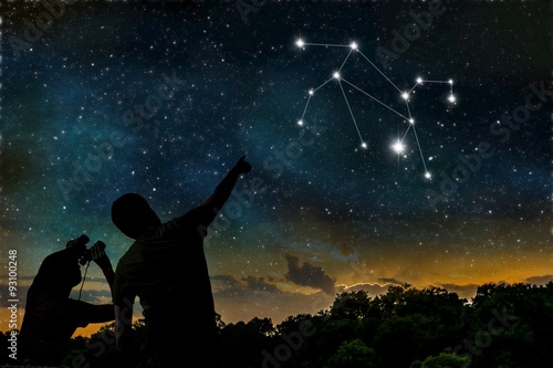 Leo or Lion constellation of zodiac on night sky. Astrology concept. Silhouettes of adult man and child observing night sky.