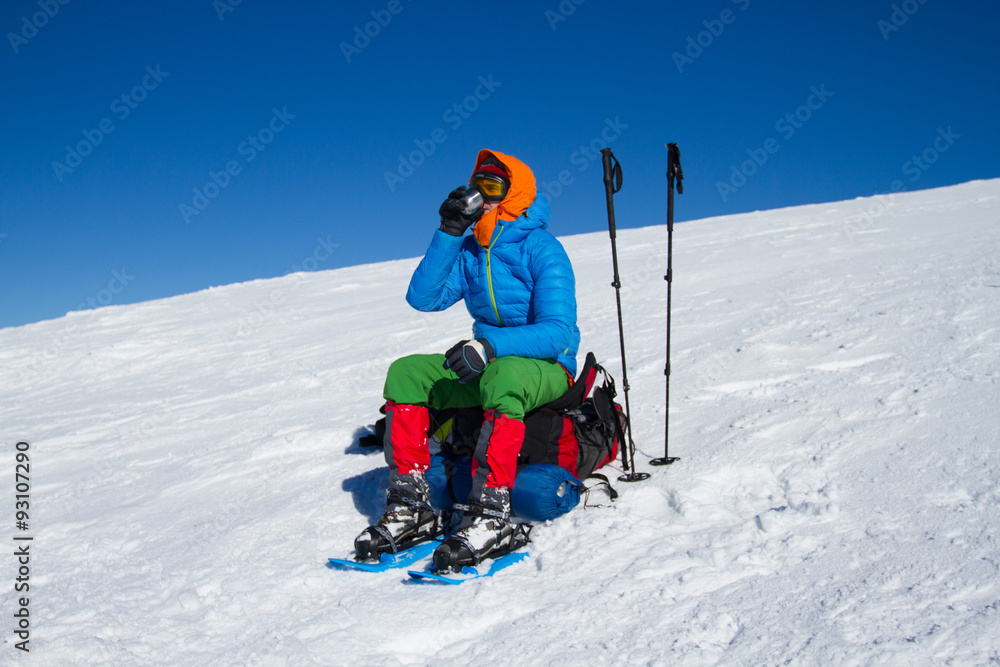 Winter hiking in the mountains on snowshoes with a backpack and tent.