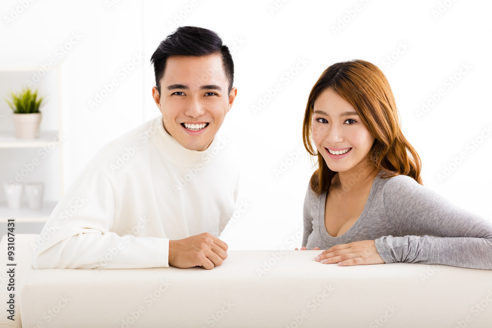 happy young couple sitting in sofa happy young couple sitting in sofa