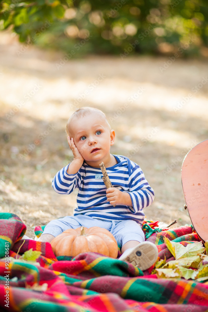 Obraz premium Kid in the park with a pumpkin
