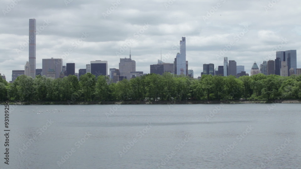The Central Park Reservoir and Manhattan skyline during cloudy spring day in New York City, USA. The Central Park Reservoir and Manhattan skyline during cloudy spring day in New York City, USA.