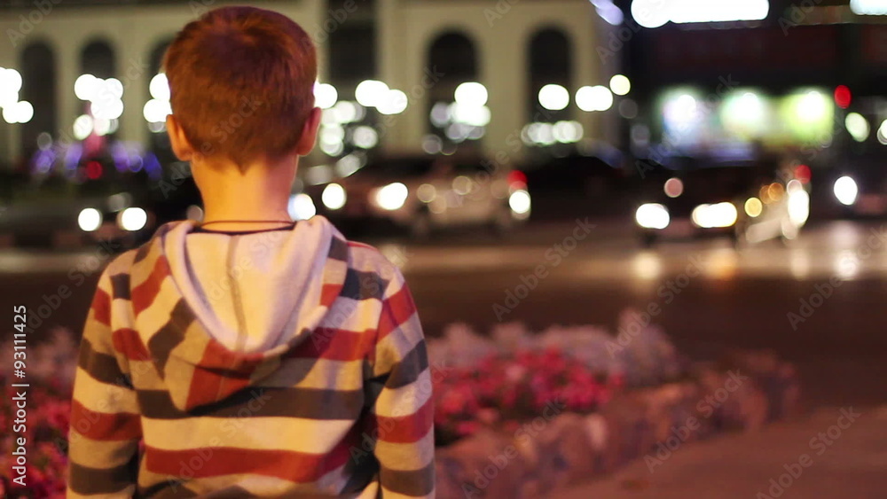 The little boy is 8 years and looks at the life of the city at The little boy is 8 years and looks at the life of the city at