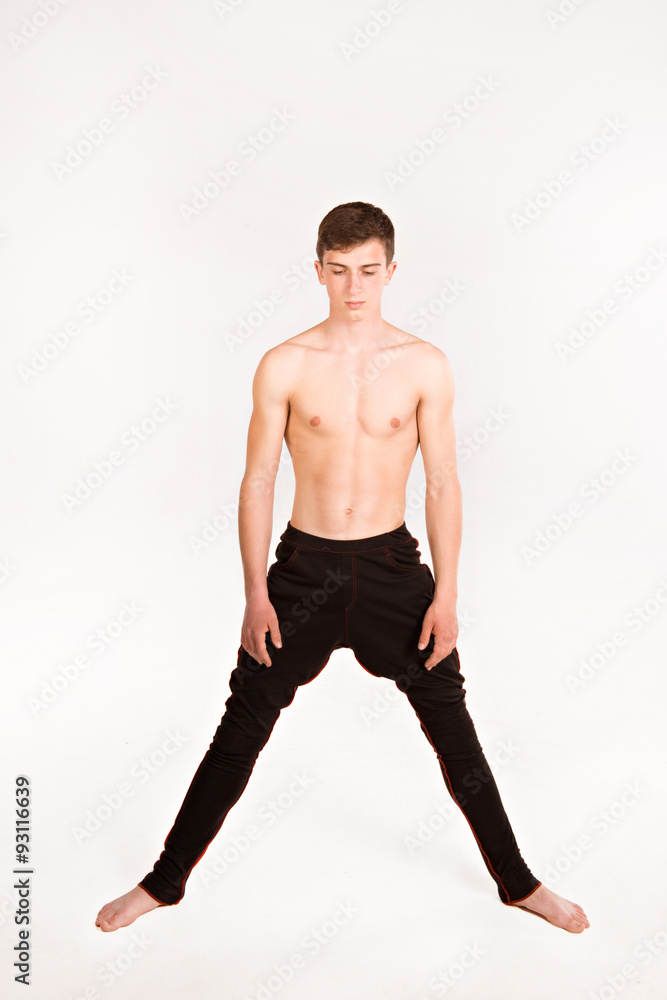 slender man doing gymnastic exercises. Gymnast standing on white slender man doing gymnastic exercises. Gymnast standing on white