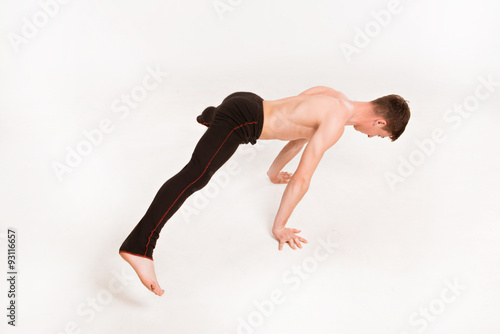 slender man doing gymnastic exercises. Gymnast standing on hands