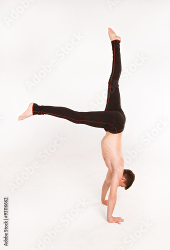 slender man doing gymnastic exercises. Gymnast standing on hands