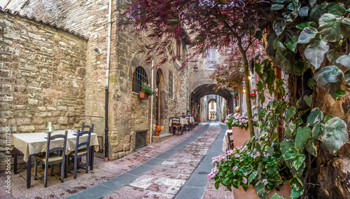 Fototapeta Naklejka Na Ścianę i Meble -  Romantic dinner place in a beautiful alley in the ancient town of Assisi, Umbria, Italy