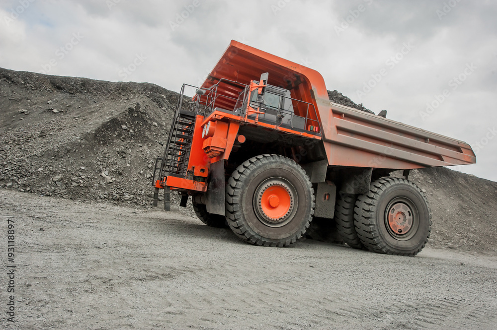 Orange mining vehicle driving in the pit