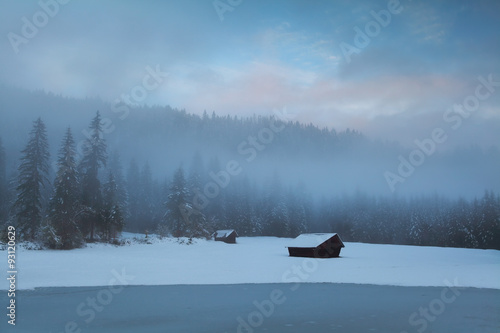 old huts in winter alpine forest