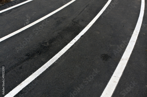 Running asphalt track with white painted lines. © pavelalexeev