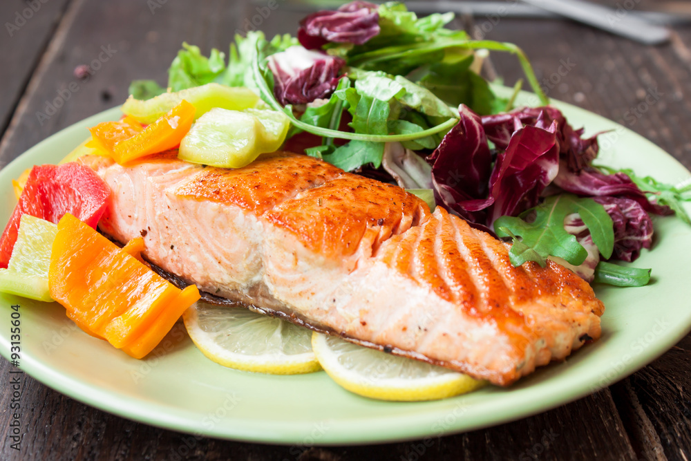 Fried salmon with vegetables on a wooden table Fried salmon with vegetables on a wooden table
