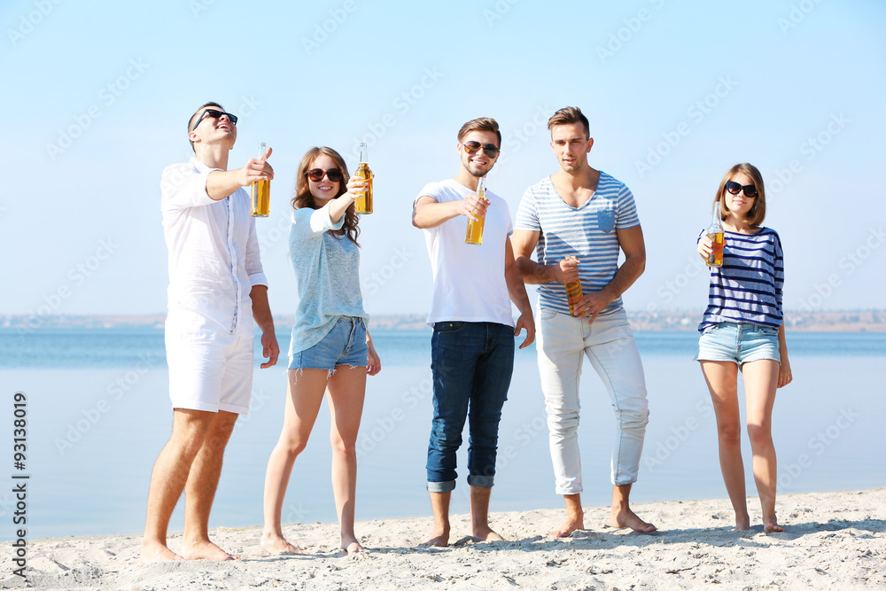 Obraz premium Young people with beer on the riverside
