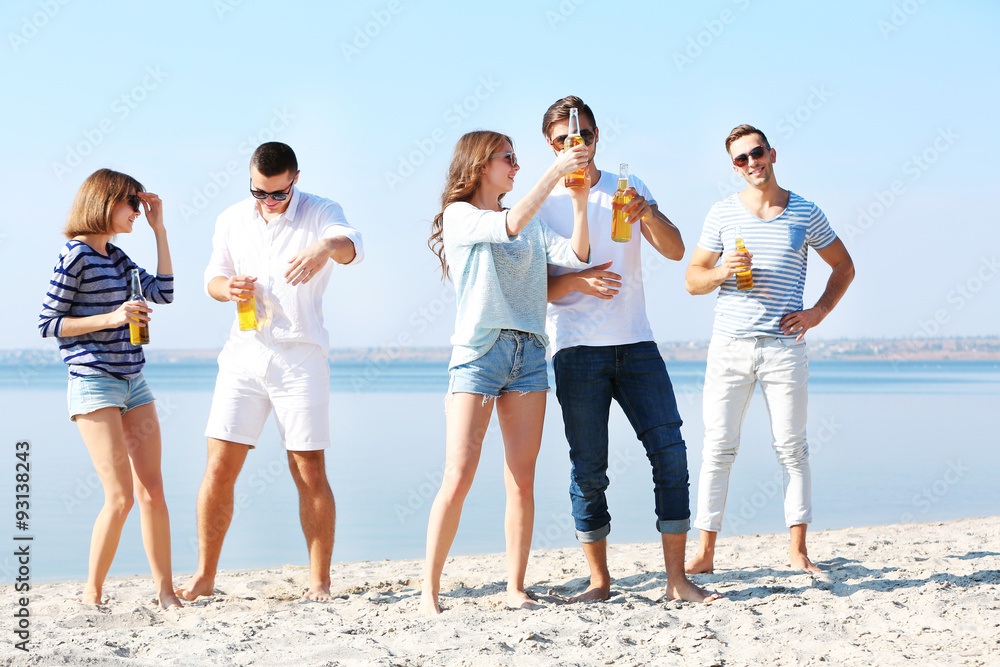 Obraz premium Young people with beer on the riverside