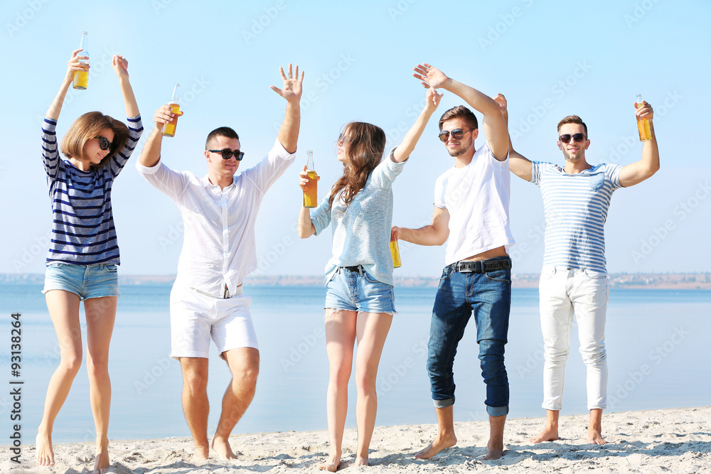 Obraz premium Young people with beer on the riverside