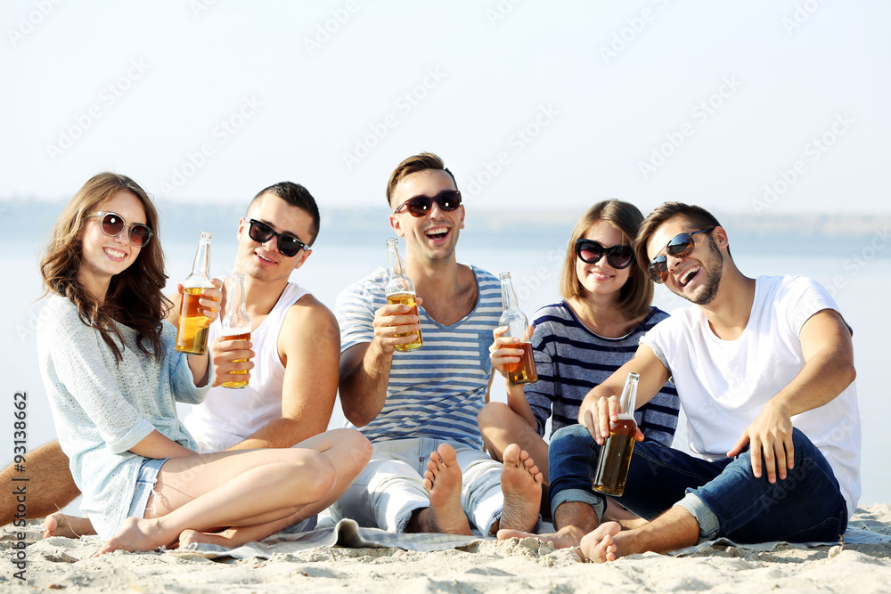 Young people with beer on the riverside Young people with beer on the riverside