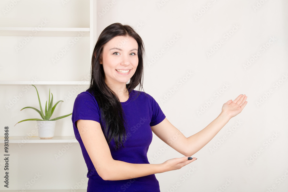 Young girl presenting empty wall at home