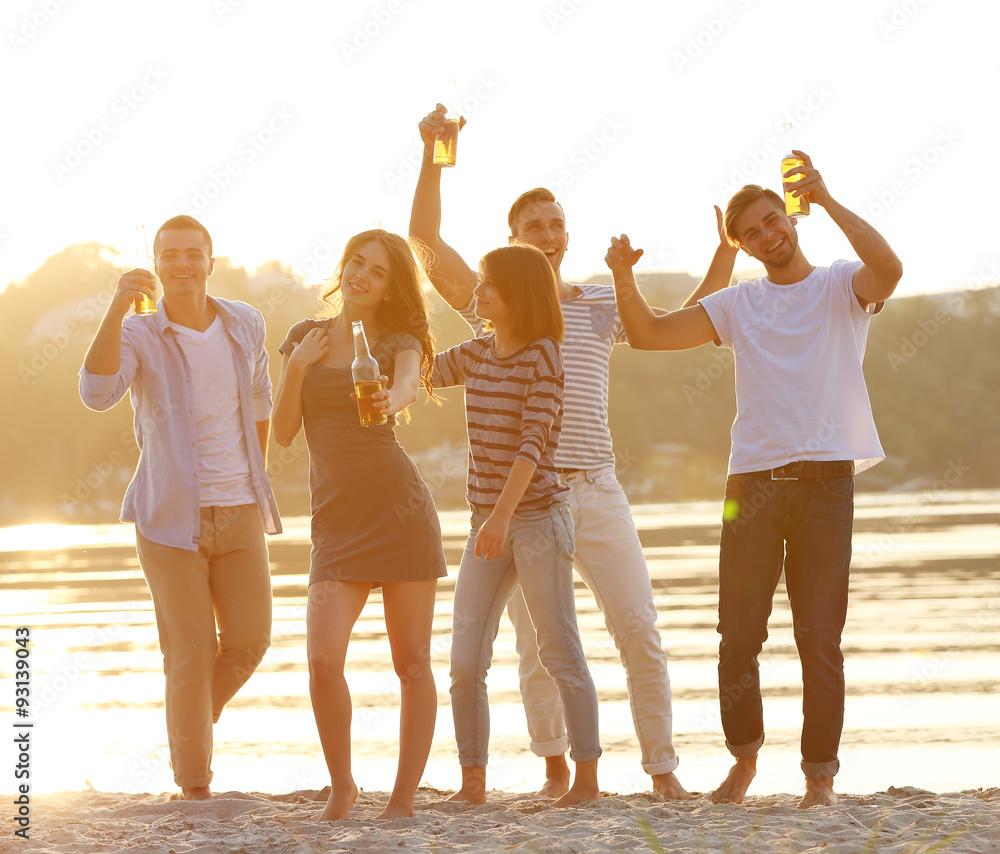 Obraz premium Young people with beer on the riverside