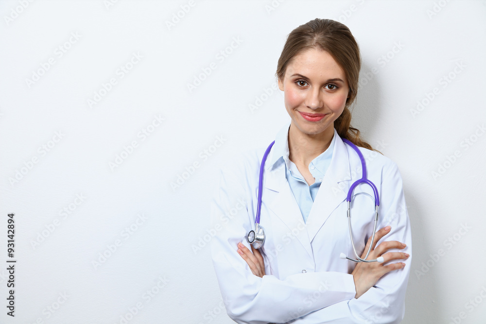 Friendly smiling young female doctor, standing near wall Friendly smiling young female doctor, standing near wall