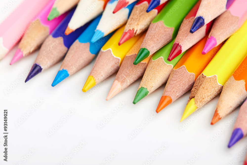Set of multicoloured pencils lying on white table Set of multicoloured pencils lying on white table
