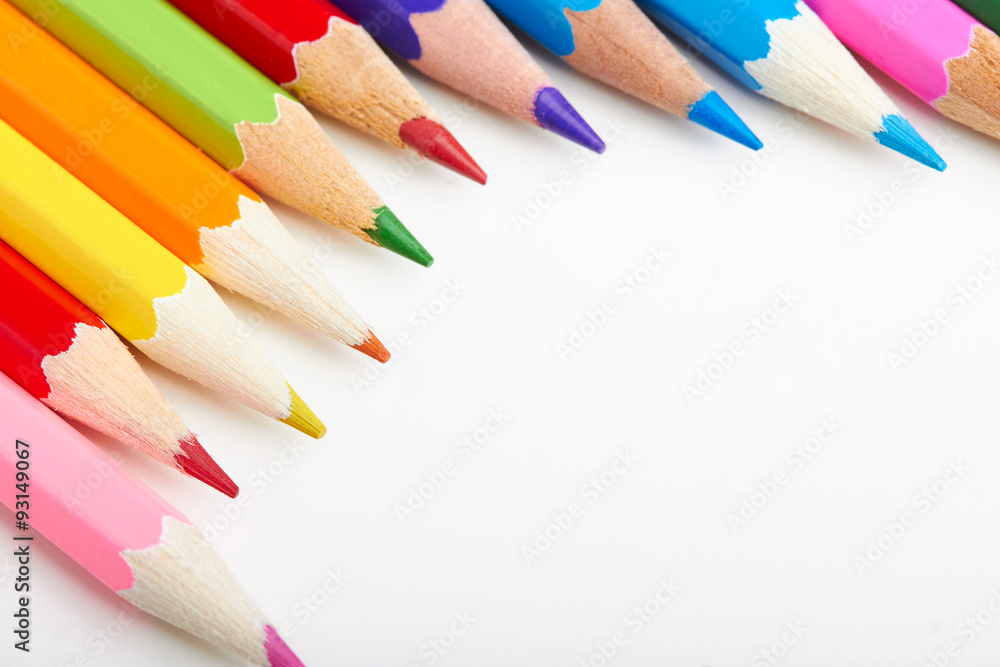 Set of multicoloured pencils lying on white table