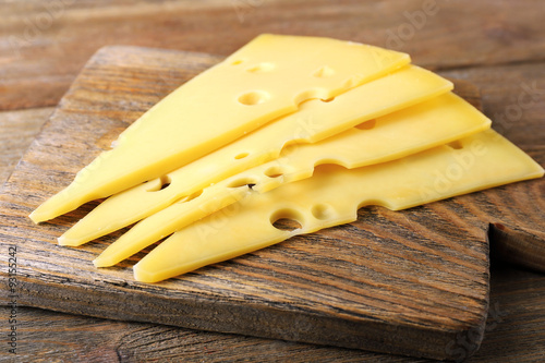 Sliced of cheese on wooden background