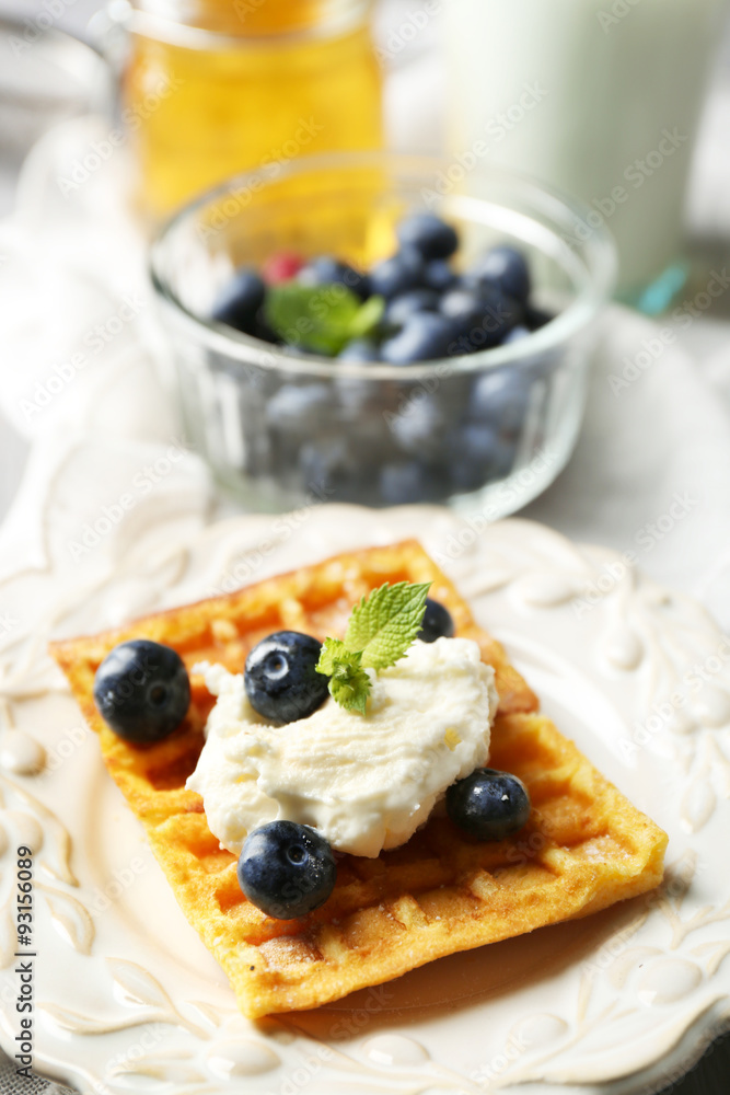 Sweet homemade waffles on plate, on color wooden background Sweet homemade waffles on plate, on color wooden background
