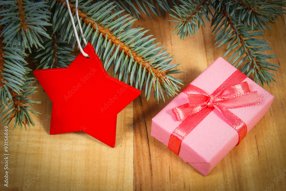 Spruce branches with red wooden star and gift for Christmas Spruce branches with red wooden star and gift for Christmas