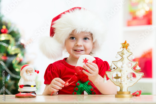 kid girl in Santa hat holdi...