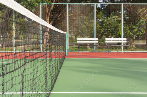 Tennis court with white benches
