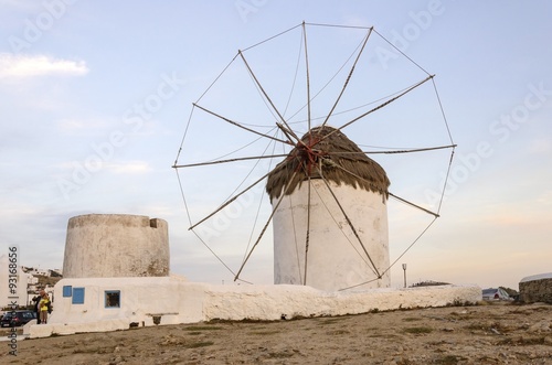 A windmill in Chora Mykonos Greece at sunset.Traditional greek whitewashed architecture popular landmark tourist destination on the island of winds against blue sky. The wind mills are now decorative.