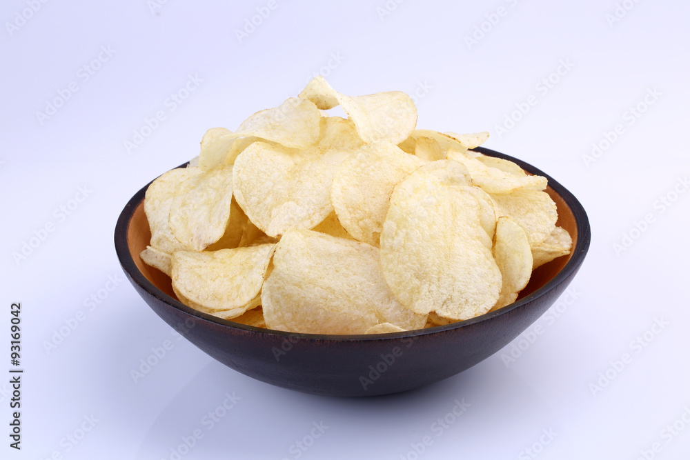 Crispy potato chips in wooden bowl isolated on white background