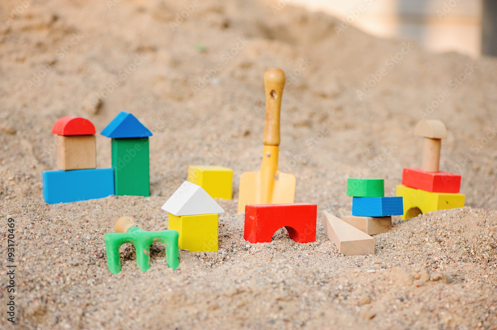 toy houses and trucks made of colorful wooden bricks in sandbox toy houses and trucks made of colorful wooden bricks in sandbox