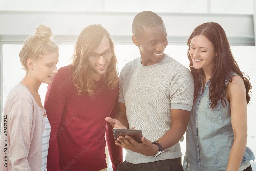 Obraz premium Smiling man showing digital tablet to coworkers 