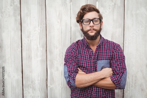 Confident hipster wearing eye glasses with arms crossed photo