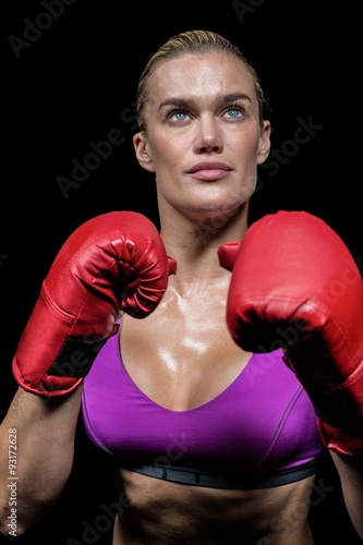Confident female boxer with gloves