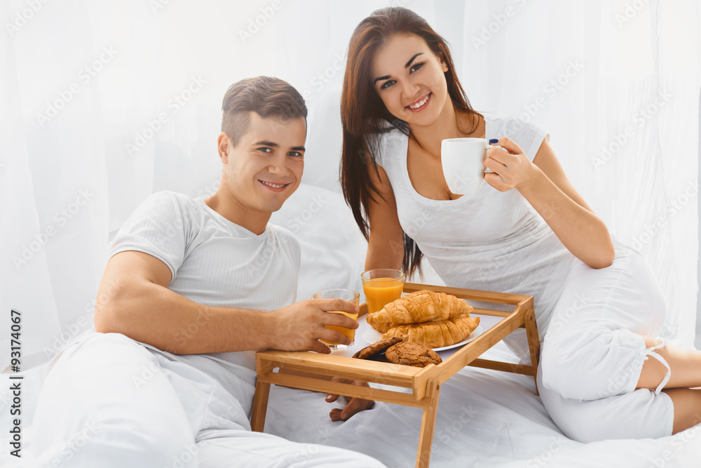 Portrait of couple enjoying breakfast in bed