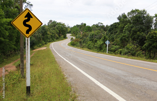 Winding road sign in the forest and mountain