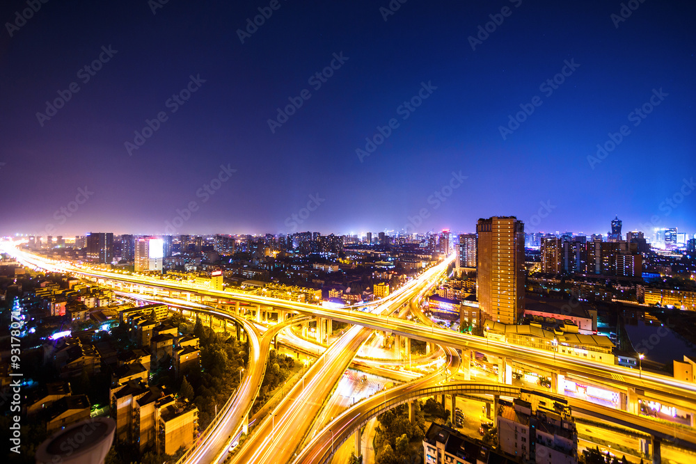 busy traffic on viaduct among modern skyscrapers at night