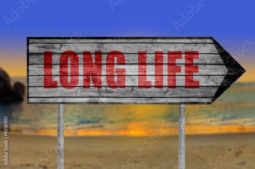 Red Long Life wooden sign with a beach background