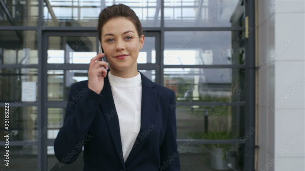 Slow motion video of beautiful businesswoman leaving from office. Confident professional using smart phone. She is walking outside office building. Slow motion video of beautiful businesswoman leaving from office. Confident professional using smart phone. She is walking outside office building.